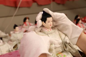 Artisan carefully handling a handcrafted Hina doll at Fujiki Crafts, showcasing traditional Japanese craftsmanship.