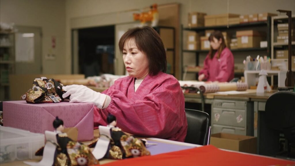 Individuals in a workshop preparing traditional items with care.