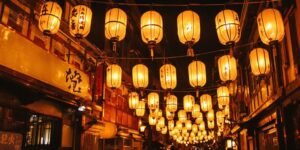 Japanese paper lanterns glowing over a nighttime street scene.