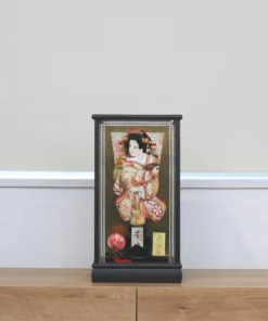 Hagoita paddle with elegant kimono-clad female figure, with gold and red embroidery, displayed on a black lacquered base and display case with decorative ball. Wholesale by Fujiki Crafts.
