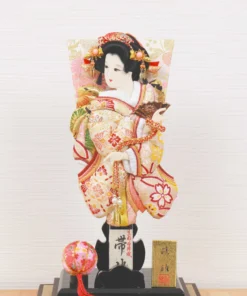 Hagoita paddle with elegant kimono-clad female figure, with gold and red embroidery, displayed on a black lacquered base and display case with decorative ball. Wholesale by Fujiki Crafts.
