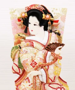 Hagoita paddle with elegant kimono-clad female figure, with gold and red embroidery, displayed on a black lacquered base and display case with decorative ball. Wholesale by Fujiki Crafts.