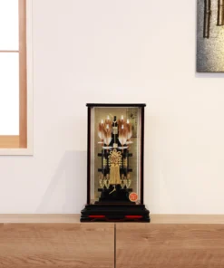 Japanese Hamaya arrow display with gold cord and tassel in black lacquer case, set against gold background with feathered arrows and symbolic ornaments. Wholesale by Fujiki Crafts.
