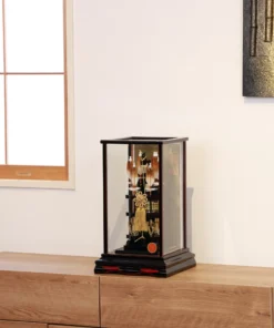 Japanese Hamaya arrow display with gold cord and tassel in black lacquer case, set against gold background with feathered arrows and symbolic ornaments. Wholesale by Fujiki Crafts.