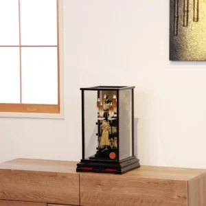 Japanese Hamaya arrow display with gold cord and tassel in black lacquer case, set against gold background with feathered arrows and symbolic ornaments. Wholesale by Fujiki Crafts.