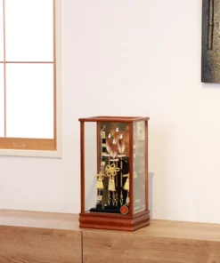 Japanese Hamaya arrow display with gold cord tassels and feathered arrows in a wooden frame case, set against a gold textured backdrop. Wholesale by Fujiki Crafts.
