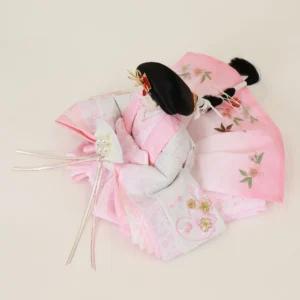 Japanese Hina Empress doll in soft pink and white kimono, holding pearl-decorated fan. Wholesale by Fujiki Crafts.
