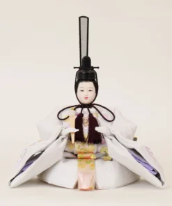 Emperor Hina doll in white patterned kimono with gold and purple accents, holding a ceremonial baton. Wholesale by Fujiki Crafts.