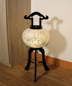 Handcrafted Japanese Bonbori-style lantern with floral washi paper shade on black lacquered wood stand, featuring pastel flowers and golden tassel. Wholesale by Fujiki Crafts.