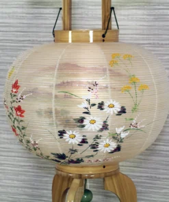 Handcrafted Japanese Bonbori lantern with washi paper shade, featuring hand-painted red spider lilies, wild daisies, and yellow rapeseed flowers on a natural wood stand. Wholesale by Fujiki Crafts.