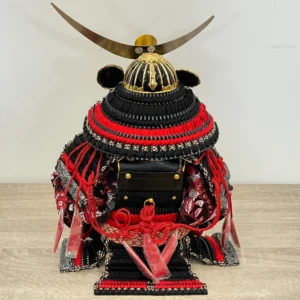 Handcrafted Japanese Samurai armor set in red and black, displayed with dragon and tiger backdrop. Wholesale by Fujiki Crafts