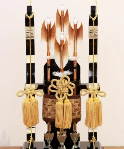 Japanese Hamaya arrows display with gold tassels, feathered shafts, and traditional Japanese accents set against a golden backdrop. Wholesale by Fujiki Crafts.