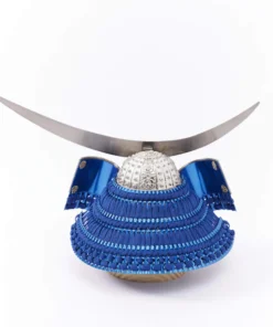 Japanese samurai kabuto helmet in silver with blue cords and tassels, mounted on a white and wood display stand with decorative folding screen. Wholesale by Fujiki Crafts.