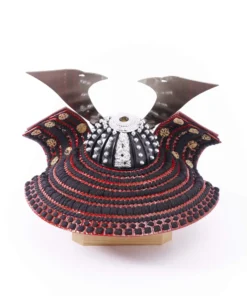 Traditional Kabuto samurai helmet with silver crest, mounted on a dark wood base, flanked by miniature sword and arrow display. Wholesale by Fujiki Crafts.