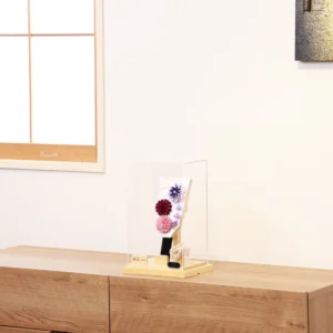 Handcrafted Hagoita paddle with purple, burgundy, and blush pink Kanzashi flowers, accented with trailing petals and displayed in a wooden base with a clear acrylic case. Wholesale by Fujiki Crafts.