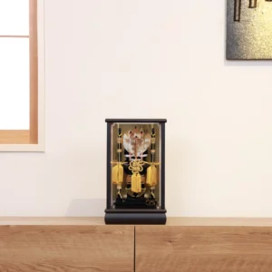 Decorative Japanese Hamaya arrow display encased in glass, featuring golden tassels, black lacquered base, and symbolic arrows with feathers, used for protection and blessings. Wholesale by Fujiki Crafts.