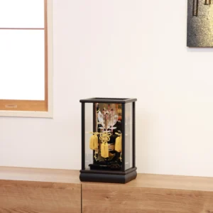 Decorative Japanese Hamaya arrow display encased in glass, featuring golden tassels, black lacquered base, and symbolic arrows with feathers, used for protection and blessings. Wholesale by Fujiki Crafts.