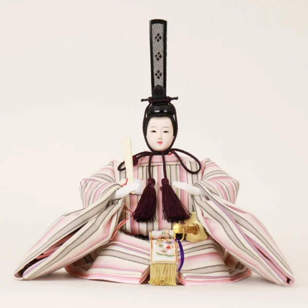 Close-up of Japanese Emperor Hina Doll in striped pastel kimono with black hat and fan, seated in formal pose on white background. Wholesale by Fujiki Crafts.