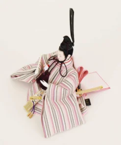 Close-up of Japanese Emperor Hina Doll in striped pastel kimono with black hat and fan, seated in formal pose on white background. Wholesale by Fujiki Crafts.