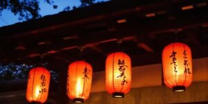 Glowing red paper lanterns illuminate a traditional Japanese temple.